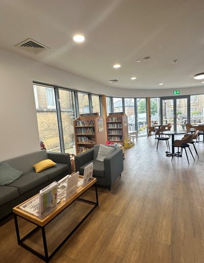 Community space inside The East Side Curve showing café-style seating arrangements